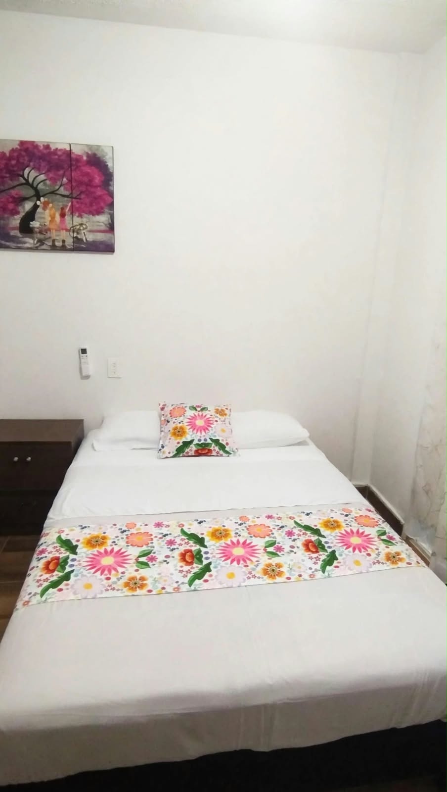 Vista de una habitación con cama y ropa de cama floral.
