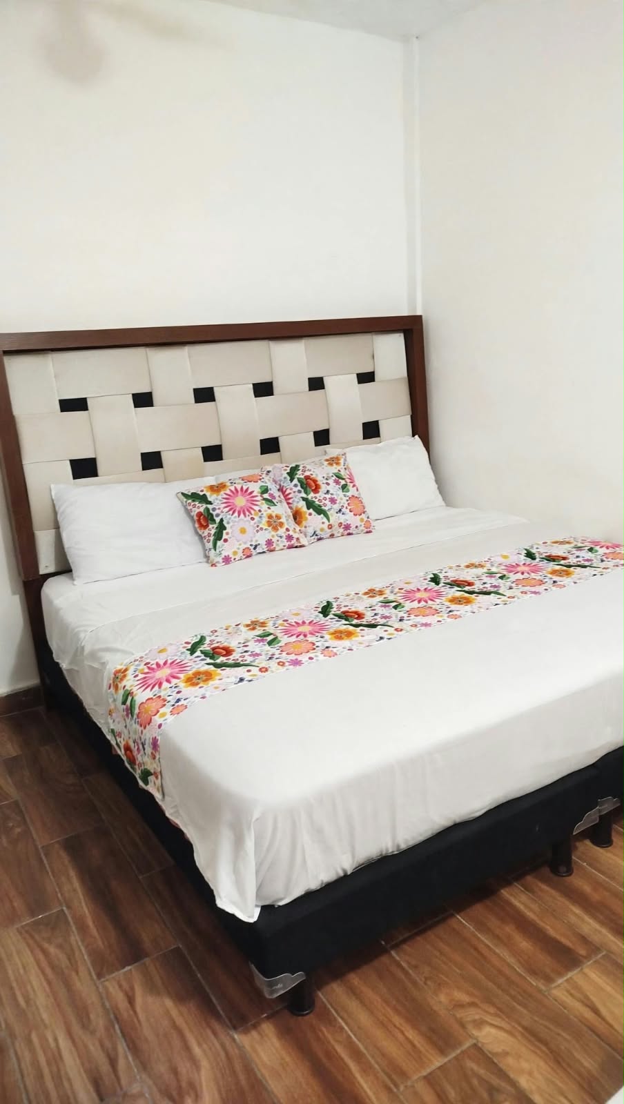 Fotografía vertical de una habitación con cama matrimonial.